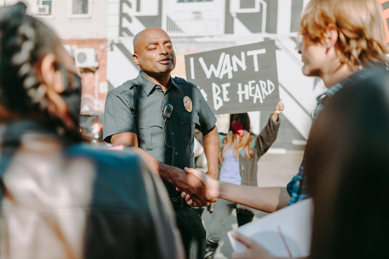 A police officer and protester share a handshake amidst a peaceful street protest.